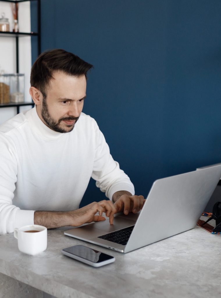 handsome-man-using-laptop-home-kitchen